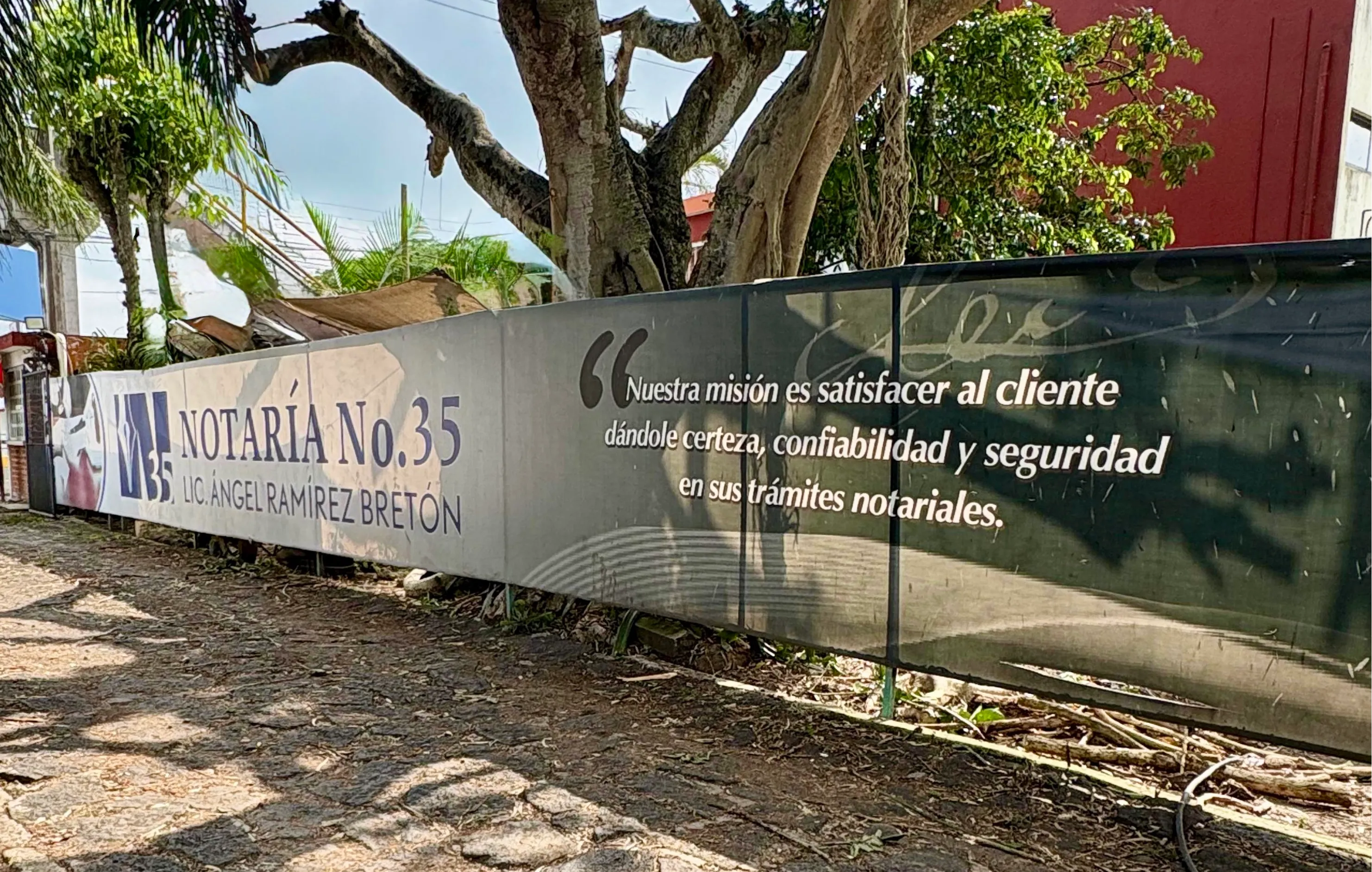 Barda de la Notaría 35 con el logotipo sobre la carretera